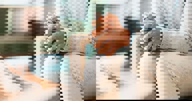 image of a person sitting with hands clasped together image of a person sitting with hands clasped together