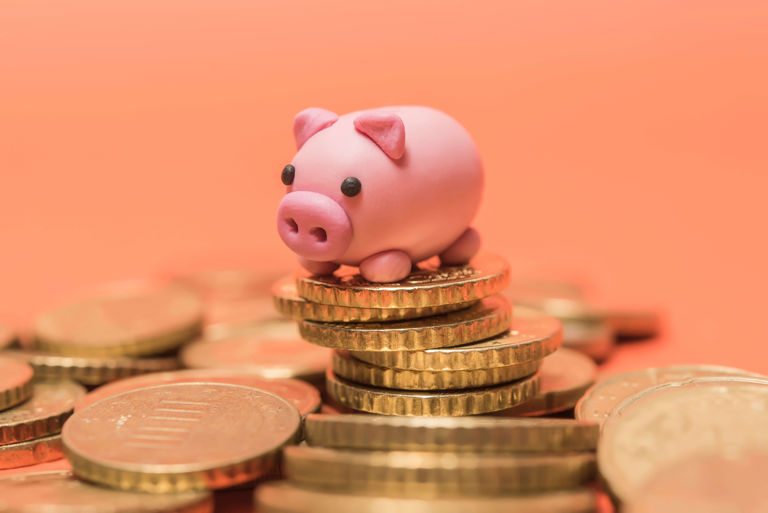 pink toy pig on top of a pile of coins pink toy pig on top of a pile of coins