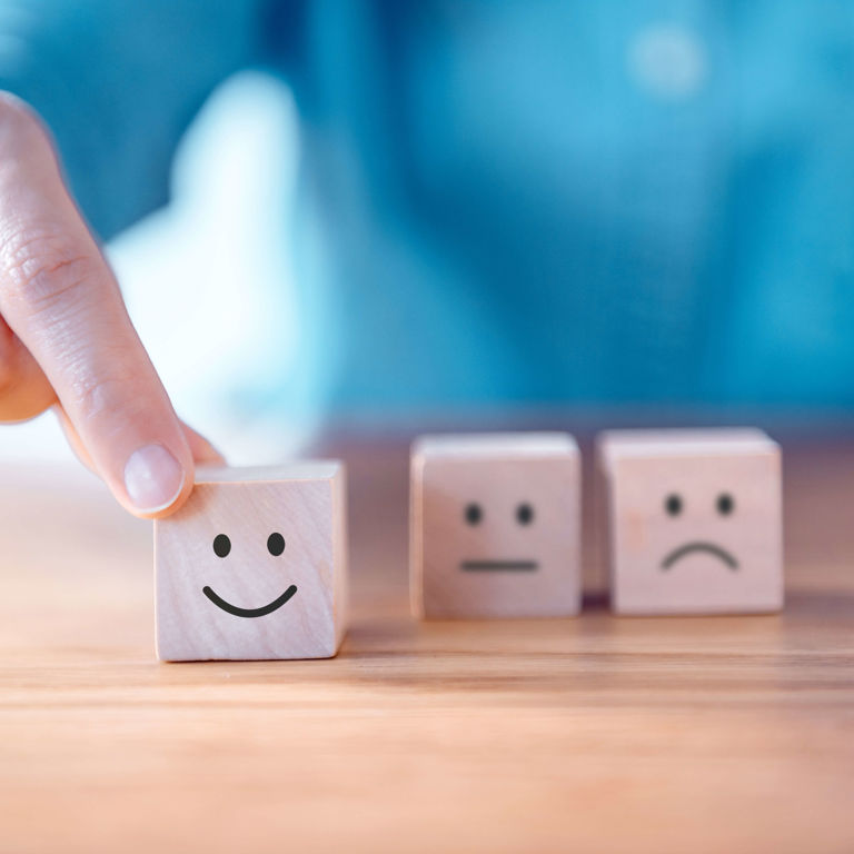 Man moving wooden smiley face froward Man moving wooden smiley face froward