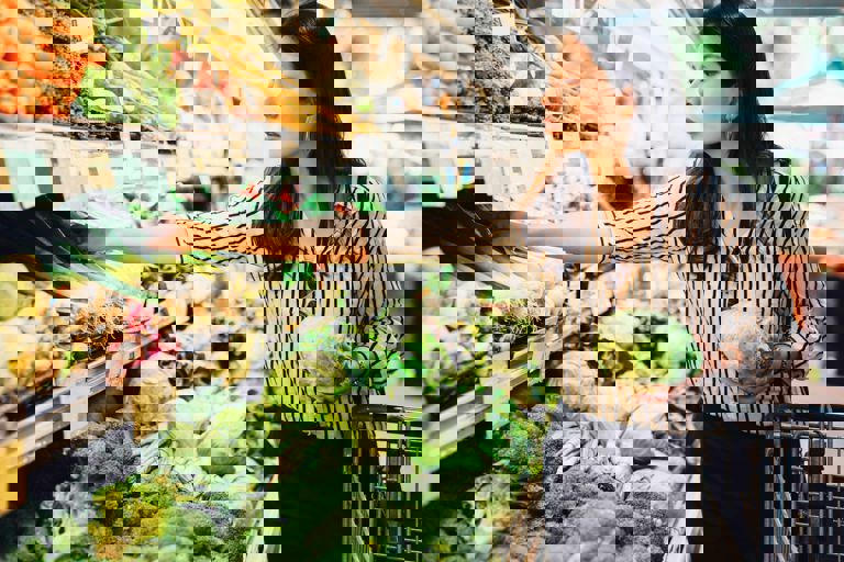 Chinese lady holding a vegetable in front of a supermarket fridge Chinese lady holding a vegetable in front of a supermarket fridge