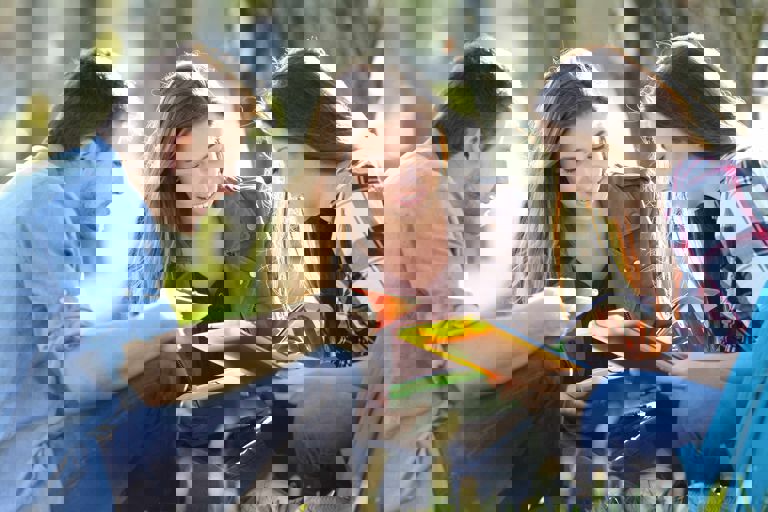 Three students sitting on the grass Three students sitting on the grass