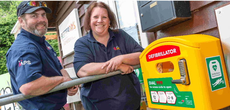 a man and woman standing next to a defibrillator a man and woman standing next to a defibrillator