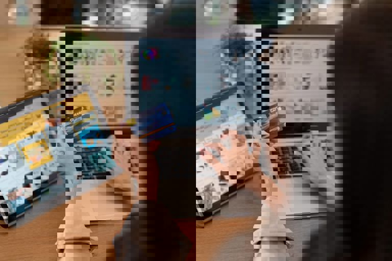 woman on laptop paying for items with bank card woman on laptop paying for items with bank card