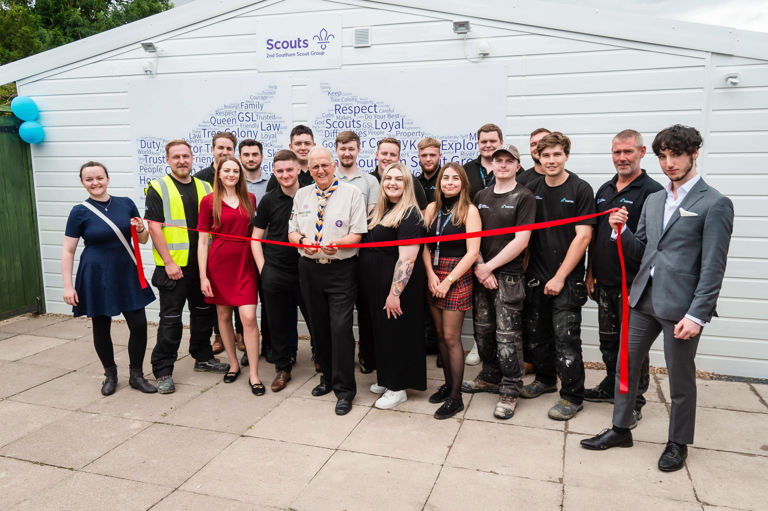 group of people standing outside a white building group of people standing outside a white building