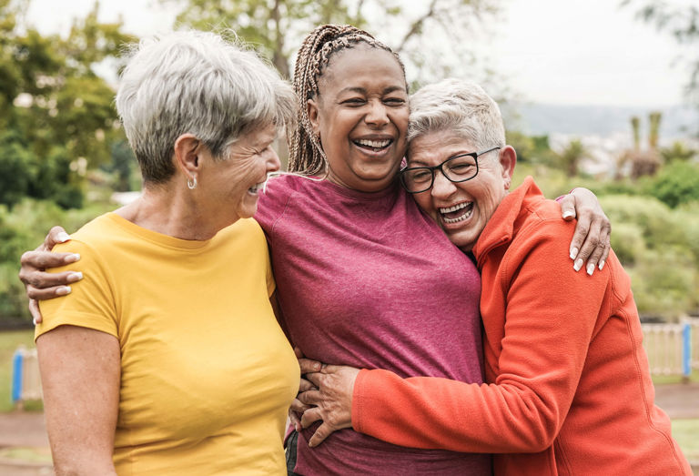 three women holding each other and laughing three women holding each other and laughing