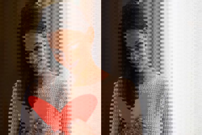 lady smiling and reading a heart card lady smiling and reading a heart card