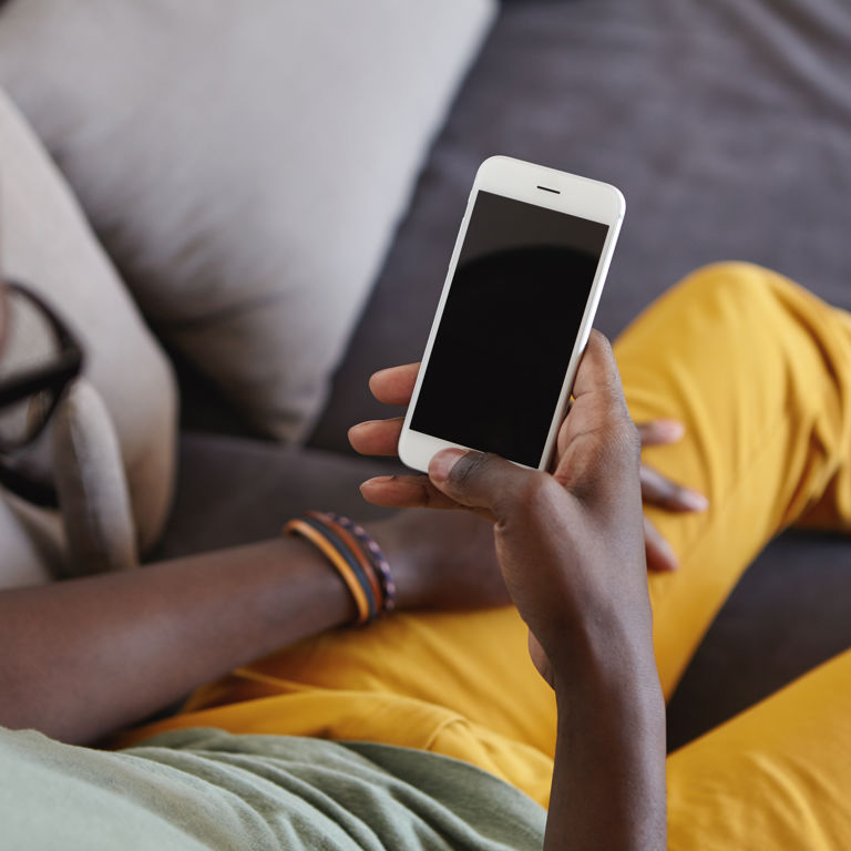 man looking at his mobile phone sitting on the couch man looking at his mobile phone sitting on the couch