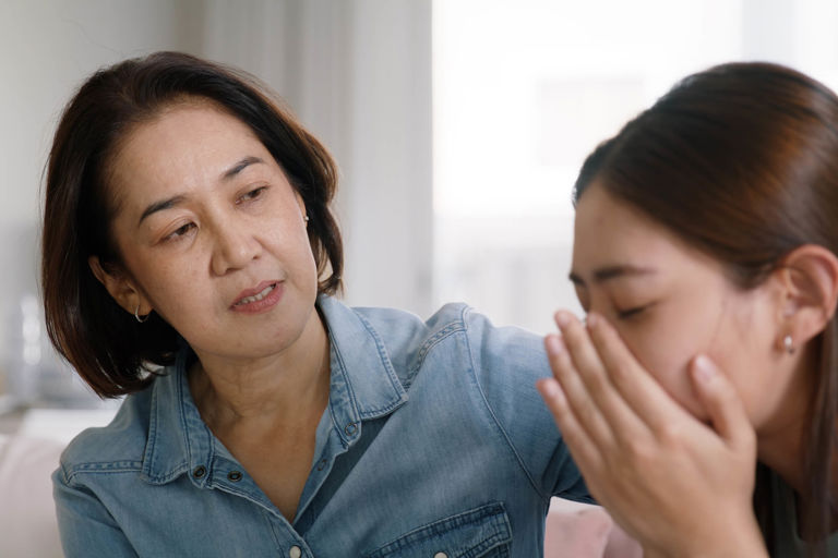 lady comforting another lady on a couch lady comforting another lady on a couch